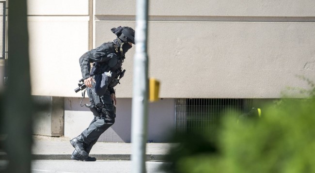 Un policía junto al cine en el que se ha producido el tiroteo. 